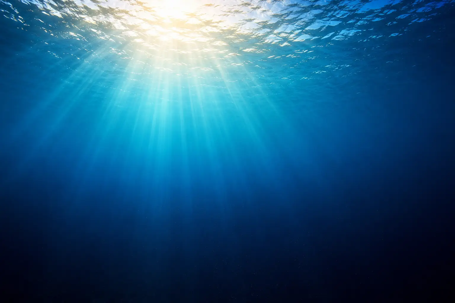Light rays penetrating deep water, colour shifting from warm at the surface toward cold blue at depth